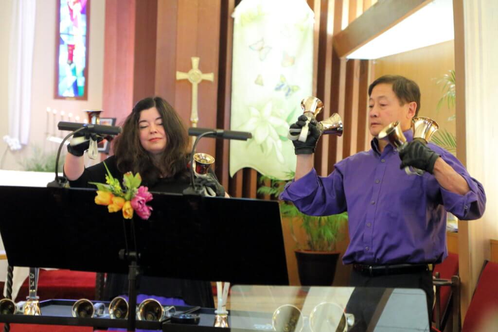 two handbell musicians in a church